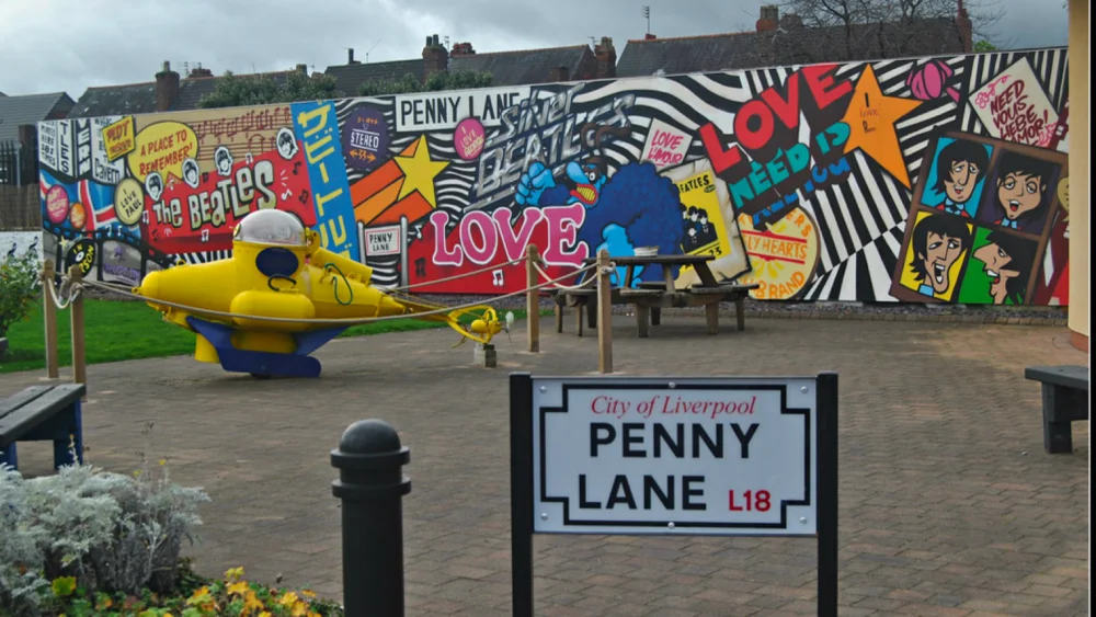 Penny Lane a Liverpool. Cartello con il nome della via e murales dei Beatles dietro