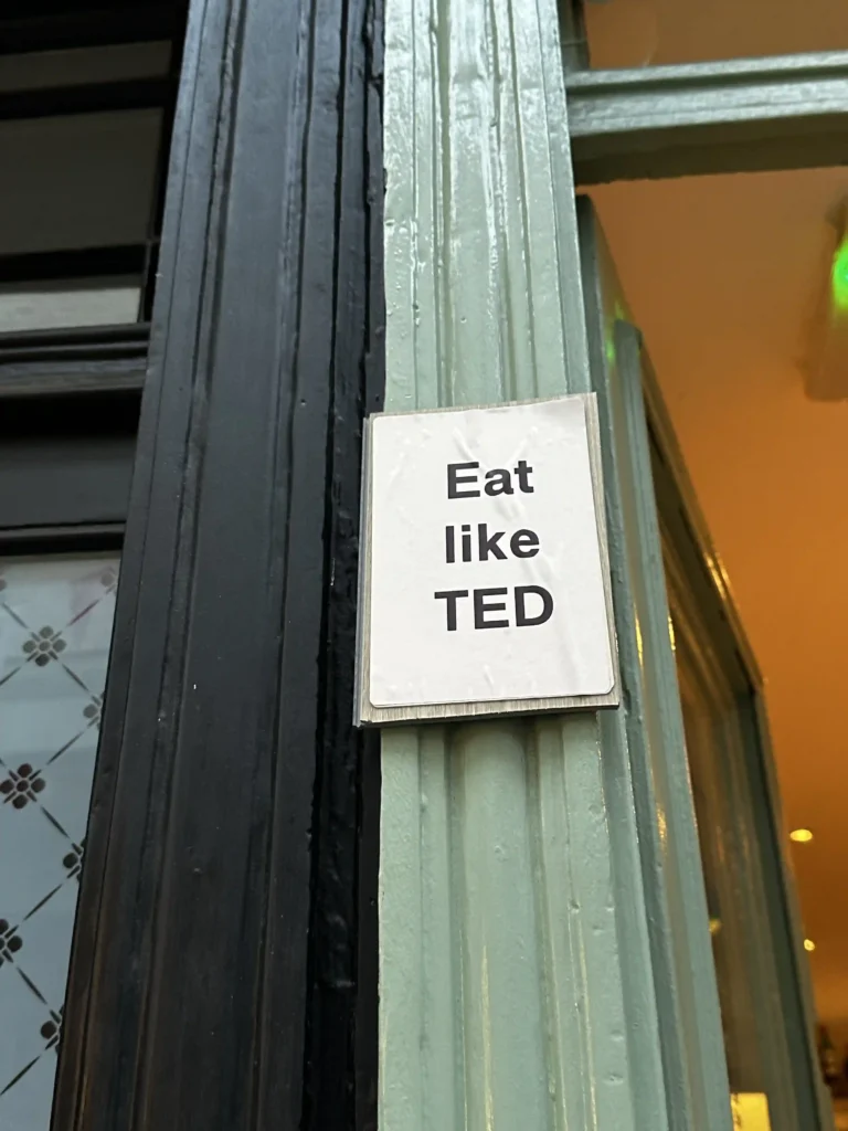 due stipiti delle porte con un cartello che recita "eat like Ted" 